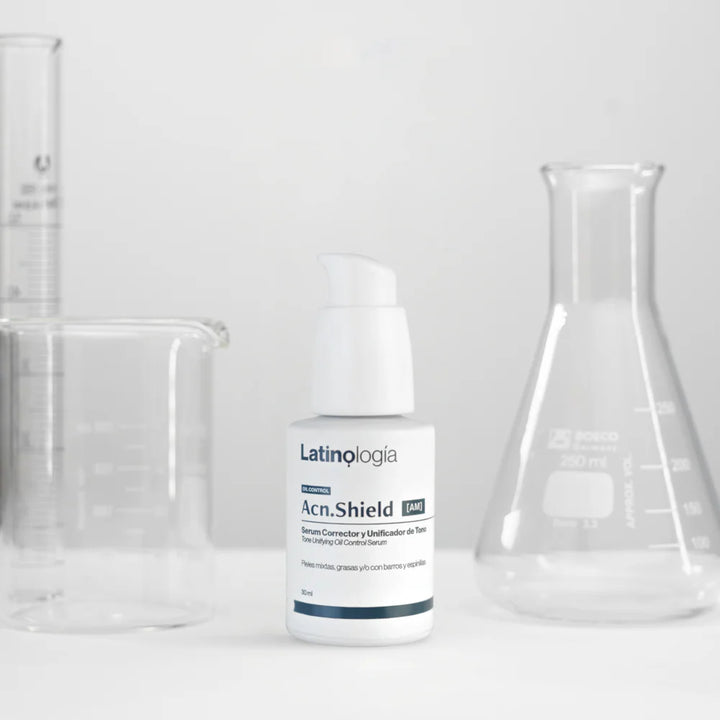 Envase de Acn.Shield Serum Corrector Latinología para unificar el tono y dar luminosidad a la piel.